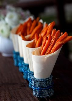 four small vases with carrot sticks in them