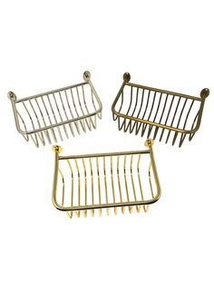 three gold - plated metal baskets with handles on each side, one holding two pairs of hair combs