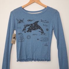 "Printed with the Tattooed Orca print. A very cool orca. Ink drawing. This cute long sleeve features ruffle trim on the cuffs and hem.  XS: Chest 15\" Length 18.5\" S: Chest 16\" Length 19\" M: Chest 18\" Length 19.5\" L: Chest 19\" Length 20\" XL: Chest 20\" Length 21\" XXL: Chest 22\" Length 22\" Product Details:  65% polyester, 35% organic cotton Wash warm, tumble dry Just so you know, everything is custom so let us know if you're looking for this print on another garment/colour.  Thanks for Trendy Long Sleeve Top With Front Print, Blue Graphic Print Long Sleeve Tops, Blue Long Sleeve Top With Graphic Print, Casual Winter Top With Front Print, Blue Surfing Tops With Screen Print, Blue Shark Design Crew Neck Top, Nautical Shirt, Loose Crop Top, Boxy Crop Top