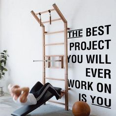 a woman is doing an exercise on a mat in front of a wall that says the best project you will ever work on is you