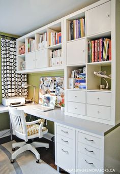 a white desk sitting under a window next to a bookshelf filled with books