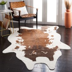 a brown and white cowhide rug in a living room