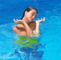 a woman in a swimming pool with her arms outstretched