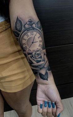 a woman's arm with a clock and rose tattoo on her left arm,