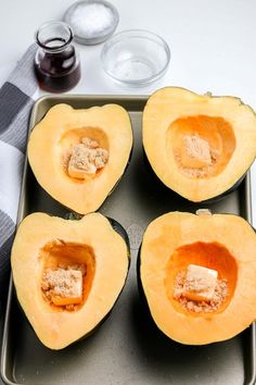 four pieces of buttered squash on a baking sheet with other ingredients in the background