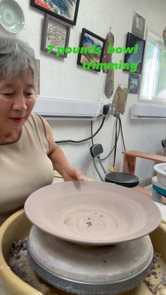 an older woman is working on a pottery wheel