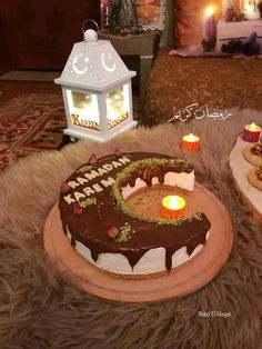 two cakes sitting on top of a table covered in frosted icing and lit candles