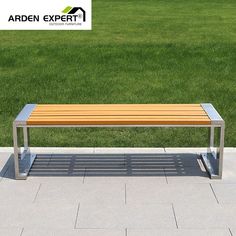 a wooden bench sitting on top of a cement slab in front of a green field