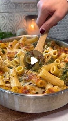 a person is spooning some pasta into a pan with broccoli and cheese