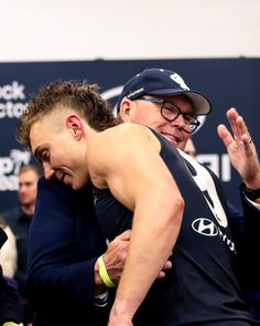 two men hugging each other in front of a crowd