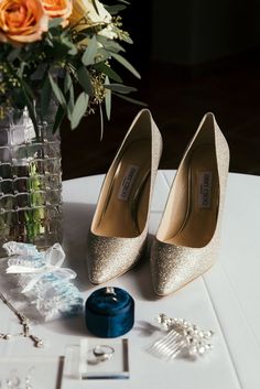 the bride's shoes and jewelry are sitting on the table next to her bouquet