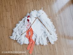 a white and orange kite laying on top of a wooden floor