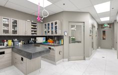 a large kitchen with lots of counter space and white tile flooring on the walls