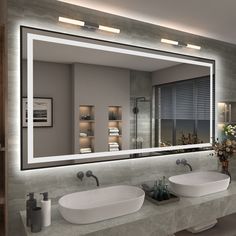 a bathroom with two sinks and a large mirror over it's sink area that is illuminated by lights