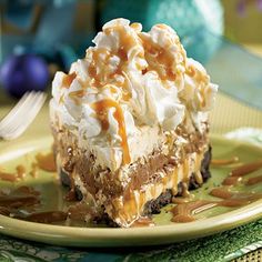 a piece of cake with whipped cream and caramel topping on a plate next to a fork