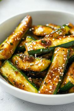 a white bowl filled with zucchini and sesame seeds