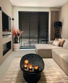 a living room filled with furniture and a flat screen tv mounted on the wall above a fire place