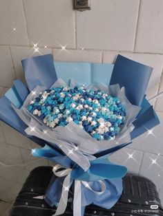 a bouquet of blue and white sprinkles on top of a black suitcase