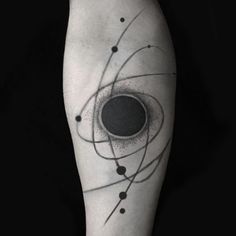 a black and white photo of an abstract tattoo on the leg with circles around it