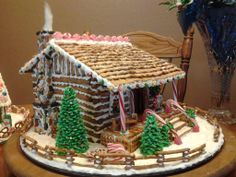 a gingerbread house decorated with icing and candy canes on a wooden table