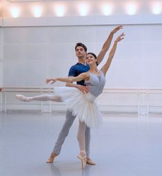 two ballerinas are in the middle of a dance class