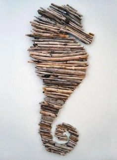 a seahorse made out of driftwood on a white background with the letter c