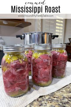 four jars filled with food sitting on top of a counter