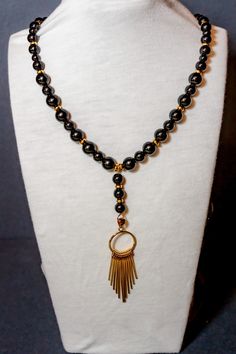 This necklace combines the timeless elegance of black and gold with the versatility to dress it up or down. Whether you're wearing it to a formal event or a casual outing, this necklace is sure to make a bold statement. Elegant Gold Necklaces With Black Beads, Elegant Gold Necklace With Black Beads, Gold Beaded Necklaces With Black Beads For Evening, Gold Beaded Necklace With Black Beads For Evening, Gold Necklaces With Black Beads For Party, Elegant Adjustable Necklace With Black Beads, Gold Onyx Necklace For Party, Elegant Black Necklaces For Evening, Elegant Black Onyx Necklace