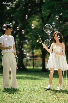 two people are standing in the grass with bubbles