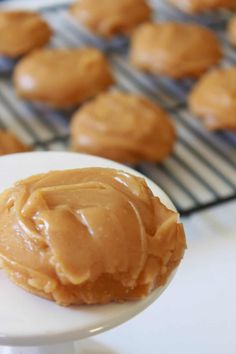 peanut butter on a plate next to some cookies and cooling rack with more cookies in the background