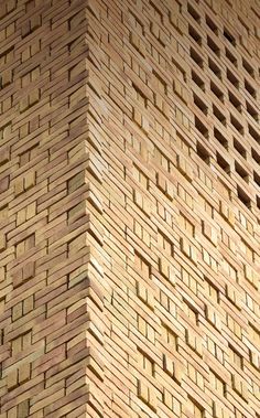 a bird is perched on the side of a wooden structure that has woven bricks in it