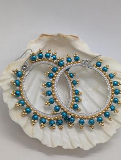 Add a touch of boho chic to your look with these stunning 2-inch Turquoise Glass & Gold Hoop Dangle Earrings. Featuring a vibrant turquoise glass bead suspended from a sleek stainless hoop, these earrings are both stylish and lightweight. Crafted with hypoallergenic materials, you can wear them with confidence all day long. Perfect for elevating any outfit, from casual to dressy, these earrings are a must-have accessory. Turquoise Beaded Teardrop Hoop Earrings, Blue Beaded Metal Hoop Earrings, Turquoise Beaded Round Earrings, Turquoise Metal Jewelry With Dangling Beads, Elegant Handmade Turquoise Hoop Earrings, Turquoise Beaded Earrings With Metal Ear Wire, Turquoise Round Bead Summer Jewelry, Turquoise Round Beads Jewelry For Summer, Bohemian Turquoise Beaded Round Earrings