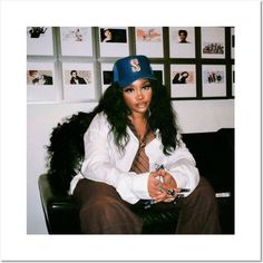 a woman sitting on top of a black chair wearing a blue hat and white shirt