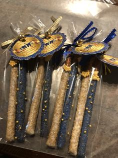 four blue and gold decorated candles in plastic bags