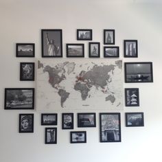 a wall with many framed pictures on it and a map hanging from the wall above