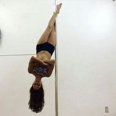 a woman is upside down on the pole