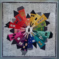 a quilted wall hanging with many different colors