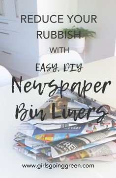 a pile of newspapers sitting on top of a white table next to a potted plant