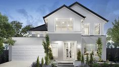 a white two story house with lots of windows and plants on the front lawn at night