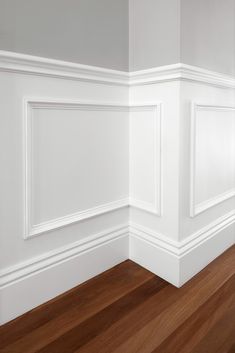 an empty room with hard wood floors and white paint on the wainscote