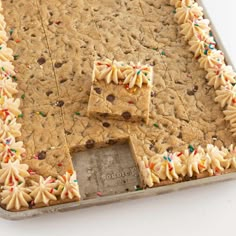 a cookie sheet with white frosting and sprinkles