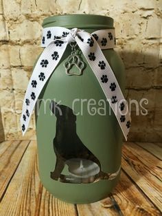 a green jar with a black dog on it and a white ribbon around the top