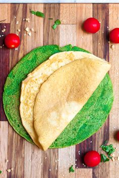 two tortillas on a cutting board with cherry tomatoes