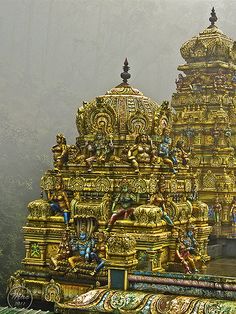 an elaborately decorated temple in the middle of a forest with lots of trees behind it