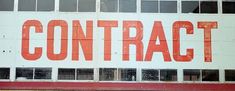 a red and white sign that reads contra on the side of a building with windows