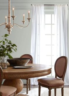 a dining room table and chairs in front of a window