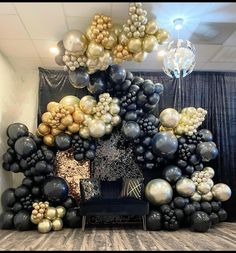 a bunch of balloons that are in the shape of a tree on a table with a chair