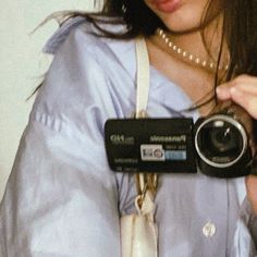 a woman holding a camera up to her face