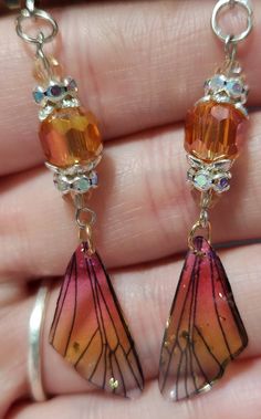 a pair of earrings that are in someone's hand