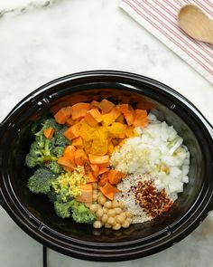 a black bowl filled with different types of vegetables